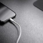 Bateria do celular acabando rápido: o que pode estar consumindo energia Celular conectado ao carregador representando bateria e consumo de energia