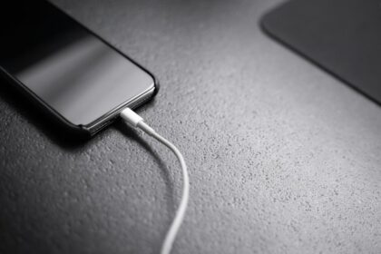 Bateria do celular acabando rápido: o que pode estar consumindo energia Celular conectado ao carregador representando bateria e consumo de energia