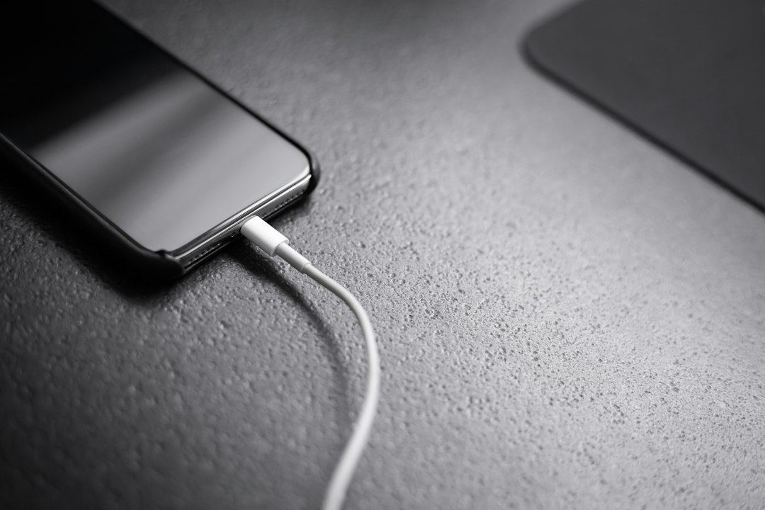 Bateria do celular acabando rápido: o que pode estar consumindo energia Celular conectado ao carregador representando bateria e consumo de energia