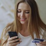 Pessoa usando celular e cartão em compra online