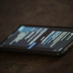 Golpe por WhatsApp se passando por governo: como reconhecer e o que não fazer Celular sobre a mesa representando mensagens suspeitas e golpes digitais