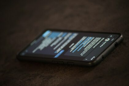 Golpe por WhatsApp se passando por governo: como reconhecer e o que não fazer Celular sobre a mesa representando mensagens suspeitas e golpes digitais