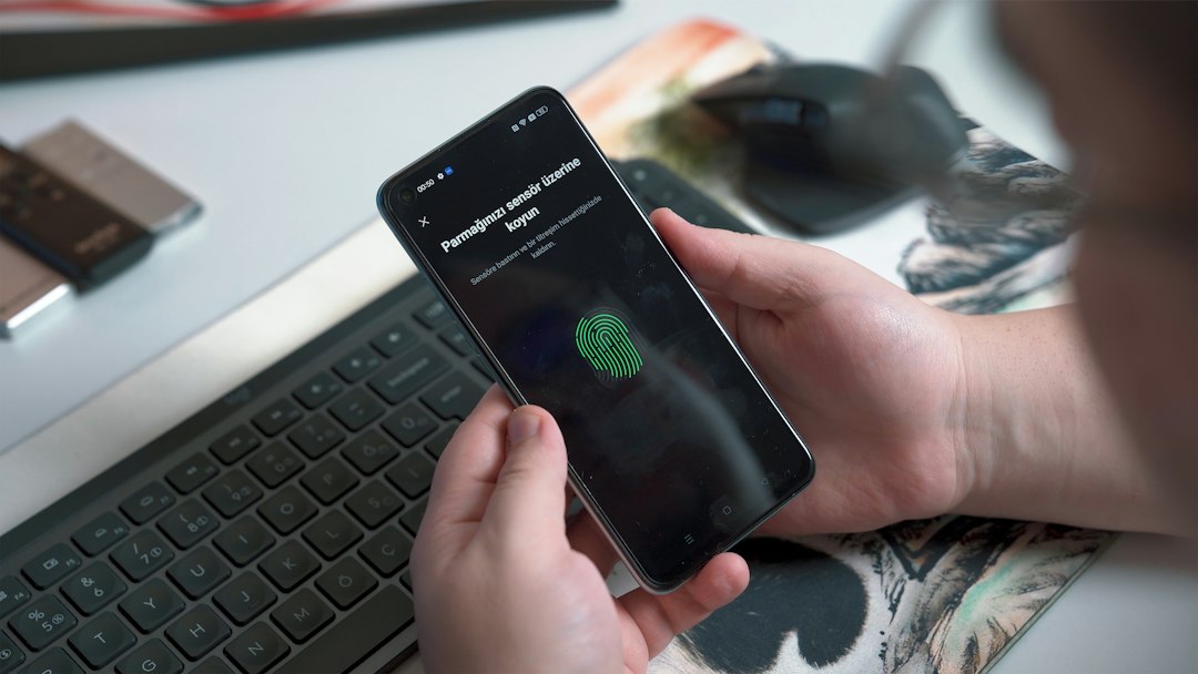 Como saber se um aplicativo é seguro antes de instalar no celular Pessoa usando sensor biométrico no celular representando segurança de aplicativos
