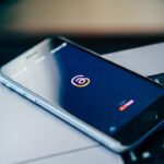 Senhas fortes sem decorar tudo: como montar um sistema mais seguro Celular sobre notebook representando segurança de senhas e contas
