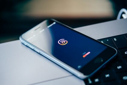 Senhas fortes sem decorar tudo: como montar um sistema mais seguro Celular sobre notebook representando segurança de senhas e contas